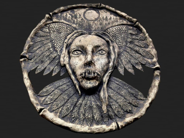 A modern representation, in metal, as a medallion of a strzyga.
From Wikimedia description: "An Old Slavic female demon with two souls, two hearts and two rows of teeth confused with a vampire. According to records, Strigas were supposed to come from girls (newborns) who were born with teeth to be able to lead the life of a predator."

Wikimedia Commons: https://commons.wikimedia.org/wiki/File:STRZYGA.jpg