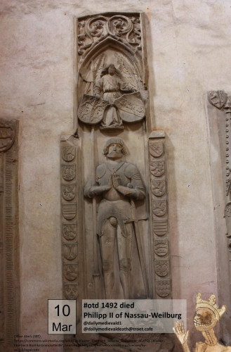 The picture shows a tomb slab, on which is a man in armor with a sword and folded hands.
