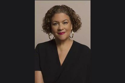 Elizabeth Alexander, president of The Andrew Mellow Foundation, wearing a black wrap dress, short sleeves, gold hoop earrings and ear length curly hair. 