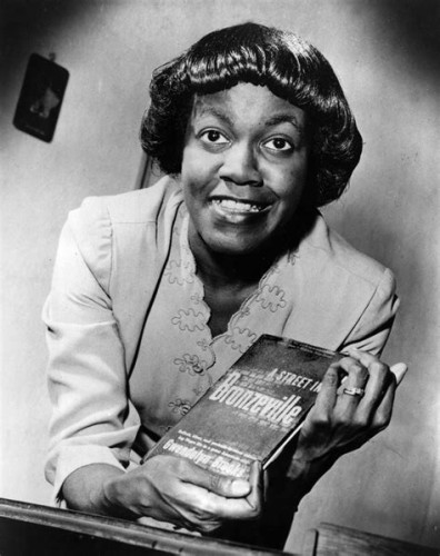 Author and Pullitzer Poet Gwendolyn Brooks
(B&W) Woman smiling while holding book ''A Street in Bronzeville''