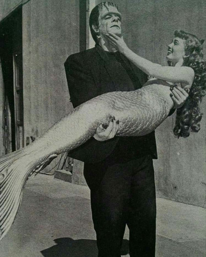 Old b&w Hollywood photo of Frankenstein's Monster carrying a smiling mermaid 