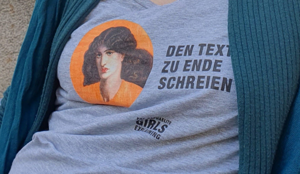 Person wearing a grey shirt with a portrait of one of the praetaffelite girls. Next to it stands "DenText zu Ende schreien" ("Scream the text to the end") in German. You only see the print of the shirt not the head of the person wearing it.