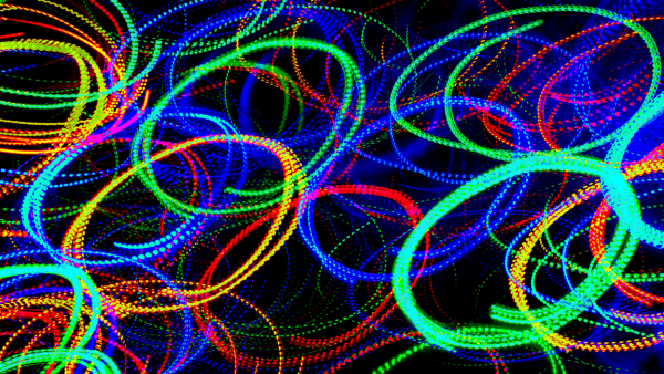 Multiple overlapping circles made of motion blurred neon lights.