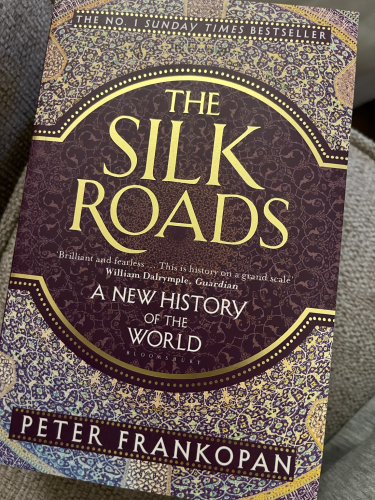 Cover of The Silk Roads with gold lettering on an ornately patterned purple background.