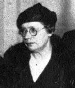 Celia Brañas in 1934. black and white head and shoulders photo of middle age white woman wearing dark hat and coat with fur collar and round glasses. 