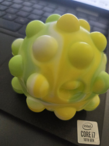 Today's fidget choice, a yellow and green pop fidget ball sitting on a keyboard
