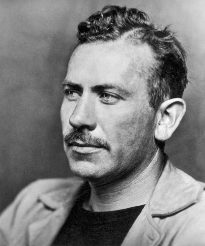 Steinbeck in 1939, wearing a t-shirt and blazer, and sporting a thin mustache. By McFadden Publications, Inc.; no photographer credited - Photoplay, November 1939 (page 22)Photograph is flipped horizontally for magazine publication, Public Domain, https://commons.wikimedia.org/w/index.php?curid=105375118