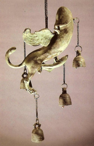 Roman tintinnabulum in the shape of a winged phallus with tail and a phallus of its own. Several bells hang from the phallus in various places.