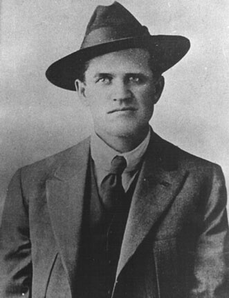 Portrait of Frank Little, in a suit and tie, and wearing a fedora. By http://www.kued.org/productions/fire/photos_stories/gibraltar.html / http://www.kued.org/productions/fire/images/gibraltar/frank_little.jpg, Public Domain, https://commons.wikimedia.org/w/index.php?curid=1897765