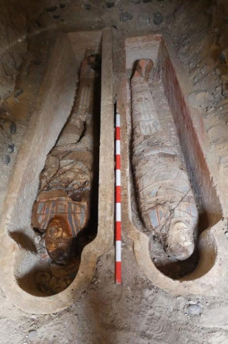 two parallel stone-cut, human-shaped tombs with mummies still inside