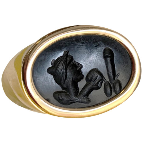 A Roman gold ring with an authentic Roman intaglio of onyx, which depicts the god Dionysos with a "mitra" on his head, a band used in Greek and Roman times to decorate one's hairstyle, a musical instrument in his hand (probably a "crotalum") and an erect winged phallus on the right.