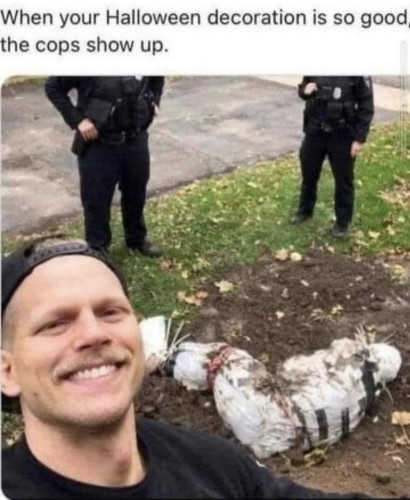 Text: "When your Halloween decoration is so good the cops show up"
With a picture of a man smiling widely as cops stand in the background around a faux body wrapped in a sheet and taped up that's lying in the dirt of his yard.