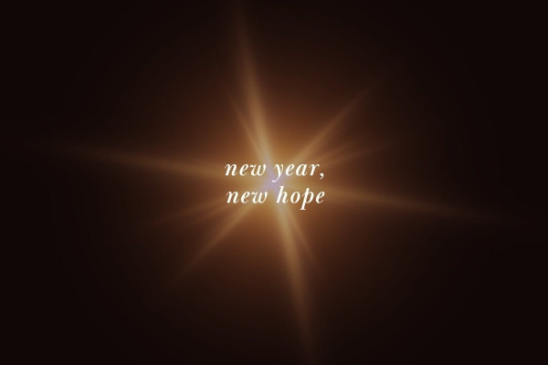 Star-shaped lens-flare against a dark background with the words "new year new hope" written on it.