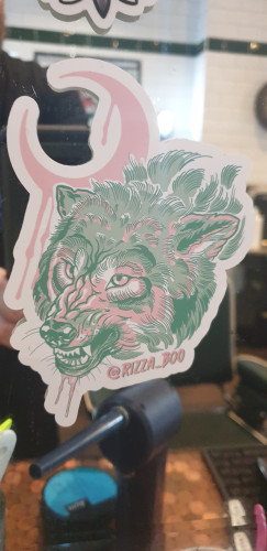 Pink and green aggressive snarling wolf with a pink crescent moon above and to the left of the picture (touching the right ear)
Drooling saliva or blood as is the moon so probably blood as the moon doesn't drool. At least not that we know about. It doesn't bleed either but you do get a blood moon.