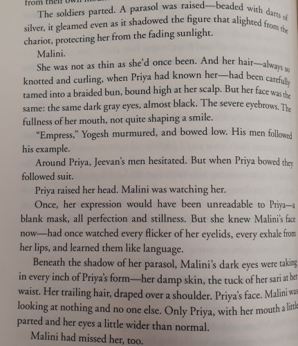 A partial page of text: "The soldiers parted. A parasol was raised-beaded with darts of silver, it gleamed even as it shadowed the figure that alighted from the chariot, protecting her from the fading sunlight.
Malini.
She was not as thin as she'd once been. And her hair - always so knotted and curling, when Priya had known her - had been carefully tamed into a braided bun, bound high at her scalp. But her face was the same: the same dark gray eyes, almost black. The severe eyebrows. The fullness of her mouth, not quite shaping a smile.
"Empress," Yogesh murmured, and bowed low. His men followed his example.
Around Priya, Jeevan's men hesitated. But when Priya bowed they followed suit.
Priya raised her head. Malini was watching her.
Once, her expression would have been unreadable to Priya - a blank mask, all perfection and stillness. But she knew Malini's face now-had once watched every flicker of her eyelids, every exhale from her lips, and learned them like language.
Beneath the shadow of her parasol, Malini 's dark eyes were taking in every inch of Priya's form-her damp skin, the tuck of her sari at her waist. Her trailing hair, draped over a shoulder. Priya's face. Malini was looking at nothing and no one else. Only Priya, with her mouth a little parted and her eyes a little wider than normal.
Malini had missed her, too."