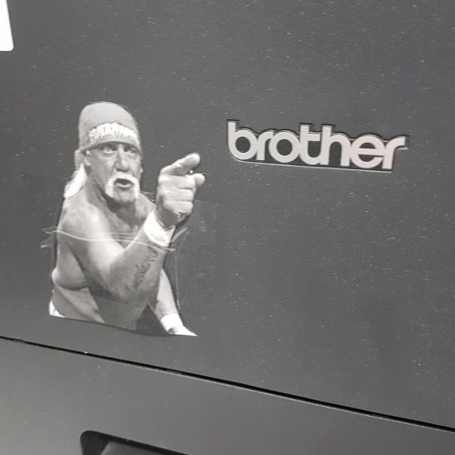 hulk hogan pointing to brother logo on the front of a laser printer