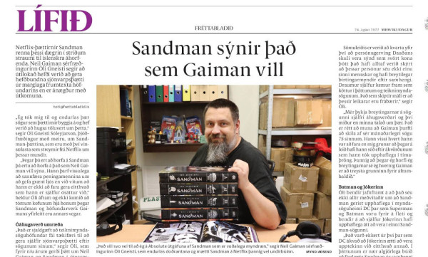 A photo of an Icelandic newspaper coverage of the TV-series adaption of Sandman. There is a photo of a bearded man (Óli) who has five volumes of Absolute Sandman in front of him.