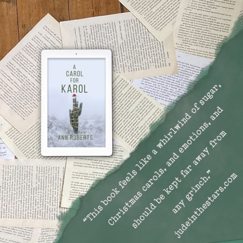 On a backdrop of book pages, an iPad with the cover of A Carol for Karol by Ann Roberts. In the bottom right corner of the image, a strip of torn paper with a quote: "This book feels like a whirlwind of sugar, Christmas carols, and emotions, and should be kept far away from any Grinch." and a URL: judeinthestars.com.