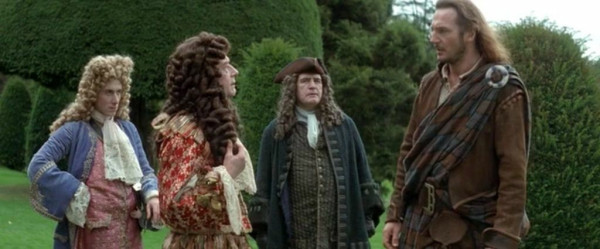 Four men stand in a manicured lawn surrounded by hedges. Three of them have elaborate curled wigs and aristocratic clothing. The fourth is wearing traditional Scottish garb