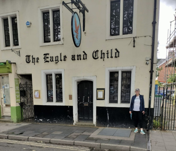 a tourist stands at the street corner where the storied Oxford pub, The Eagle and Child, home to The Inklings, stands shuttered.  