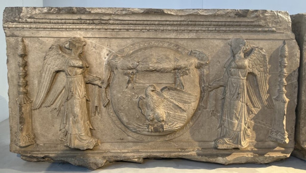 Description from the museum: “The trophies, breastplates, shinguards and shields surrounding the helmeted head of Athena, Dioscuri on horseback or a winged snake, exquisitely engraved on the stone, can all be related to a great military triumph. The motif of the two Victories holding a wreathed shield decorated with an eagle with lightning between its claws (alluding to a military success) unmistakably confirms the celebratory intent of the monument.”