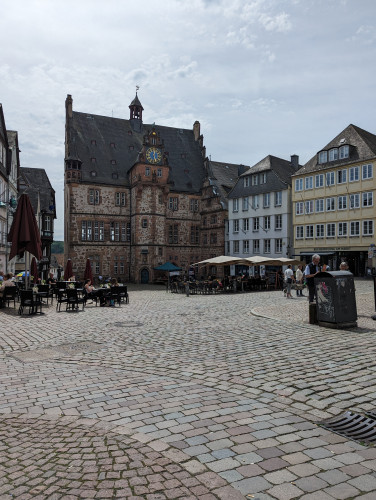 Das Foto zeigt das historische Rathaus von Marburg mit davor liegendem Platz.