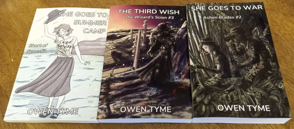 Physical copies of three of Owen Tyme's books, She Goes to Summer Camp, The Third Wish and She Goes to War.

The books are laid out side by side.