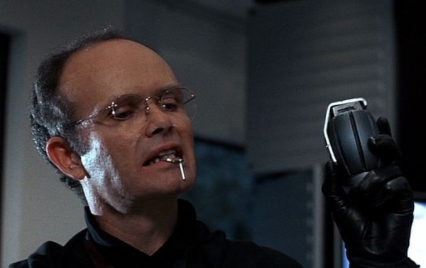Clarence Boddicker holds the safety ring for a grenade in his mouth.