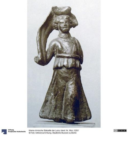 Photo of a Roman bronze statuette of the moon goddess Luna. The photo was taken before the 2nd World War and has been damaged during the war. On the photo, we see her with a crescent moon on her brow, a billowing cloak on her right and missing right hand, the arm and cloak missing completely on her left. She is dressed in a peplos girded below the breasts.