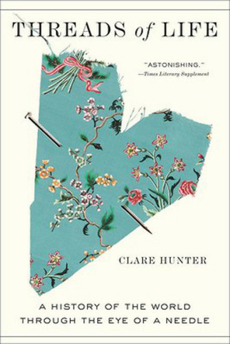 Cover of 'Threads of Life' by Clare Hunter showing a roughly cut heart in a patterned fabric with a straight pin running through the middle of it.