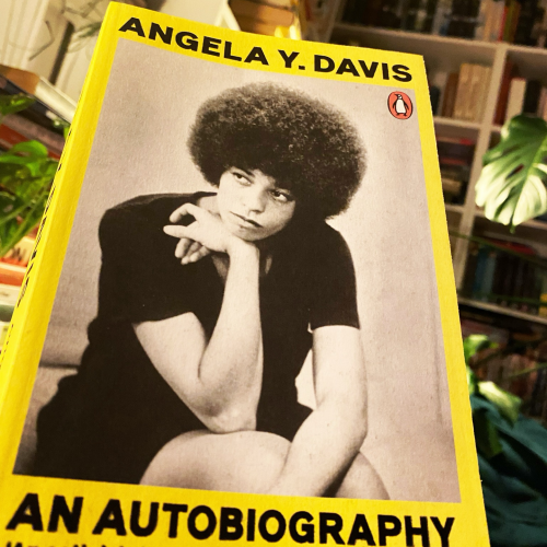 Cover of Angela Y. Davis’ Autobiography. On a bright yellow background, showing a photograph of the author as a young woman. 