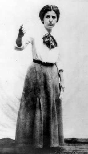 Elizabeth Gurley Flynn pointing. She is wearing a white blouse and long, pleated skirt. Public Domain, https://commons.wikimedia.org/w/index.php?curid=456361