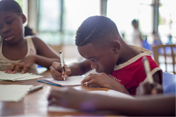 Young Black male student pores over assignment during class.