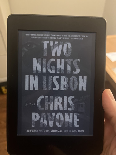 Cover of Chris Pavone’s Two Nights in Lisbon on a Kindle e-reader.