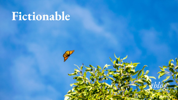 A monarch butterfly comes in to land high in a tree against a blue sky, with the legend 'Fictionable #blog'