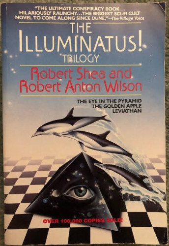 Paperback cover of "Illuminatus!" by Robert Shea and Robert Anton Wilson with three dolphins swimming over an eye in a pyramid on a checkerboard. 