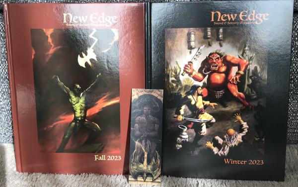 The New Edge Sword & Sorcery Magazine Fall 2023 and Winter 2023 issues. The Fall issue cover shows a trans man barbarian raising an axe aloft. The Winter issue cover shows people in Asian garb being attacked by a three-eyed ogre.