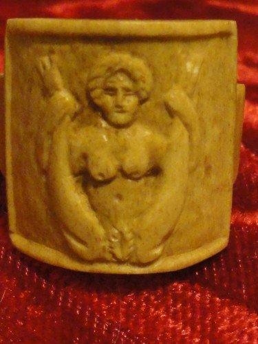 A relief depicting a naked Baubo holding up her legs to expose her vulva.