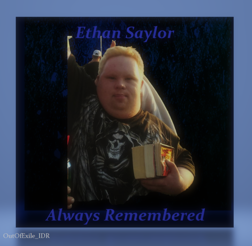 Photograph of Ethan Saylor raising his arm in the air and holding books in his other hand with sunlight highlighting the right side of his image. The blue and black gradient background is framed in light blue. The words "Ethan Saylor – Always Remembered" are superimposed on the image.  In the bottom quarter in small gray text reads "Out Of Exile_IDR".