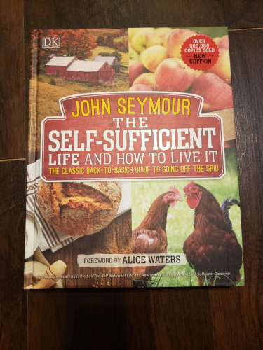 Book cover of John Seymour's "The Self-Sufficient Life and How to Live It"

Features pictures of farm life, including chickens, a loaf of fresh baked sourdough bread, a farm house, and some apples.