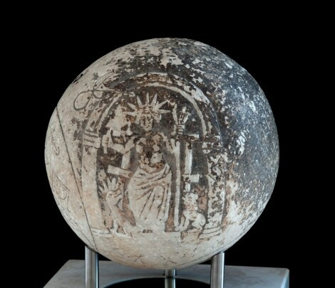 Engraved marble ball (magic sphere?) with Helios and magical symbols. The sun god is seated on a throne below an arch, wearing his seven-spiked sun ray crown. Two animals sit to his feet.