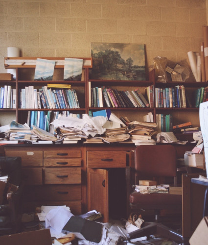 A very cluttered desk inside an abandoned science lab.