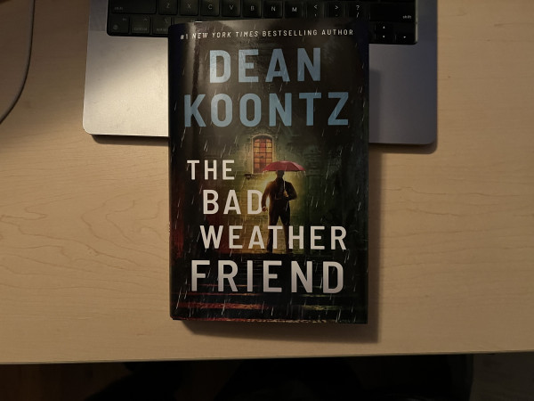 Cover of Dean Koontz's The Bad Weather Friend. Cover art is a large man in the shadows holding a red umbrella