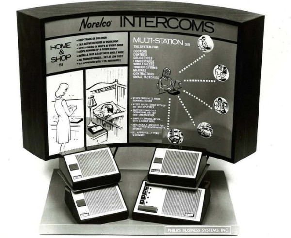 Image of a 1960s-era intercom system. Black and white image. In front is the central intercom control with five buttons and then three peripheral parts of the networked system with a curved concave marketing display that states "Home and Shop" and Multi Station with images.
