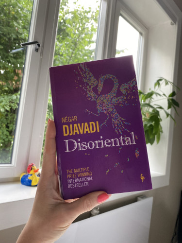 photo of the cover of Disoriental by Négar Djavadi. the cover is purple with a bird/swan/phoenix shape made of tiny colourful pieces that look like tutti-frutti sprinkles