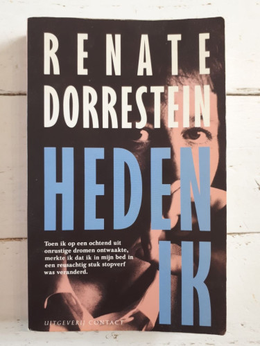 The book "Heden ik". It is a paperback with the title and the author's name in big letters on the cover.  In smaller letters the text "Toen ik op een ochtend uit onrustige dromen ontwaakte, merkte ik dat ik in mijn bed in een reusachtig stuk stopverf was veranderd." In the background is a portrait of a woman, probably Renate Dorrestein.  