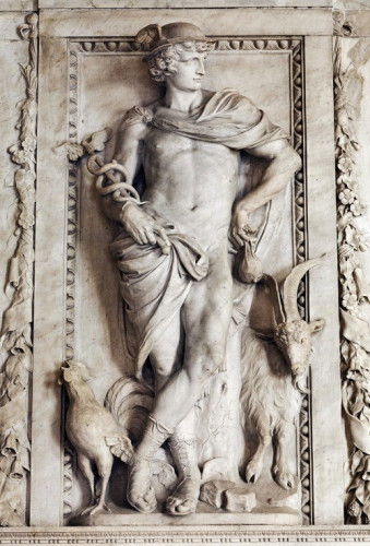 Neoclassical relief of Hermes, covering his nudity with his cloak that he wears pinned over the right shoulder. To his feet stand a cock and a ram. Hermes wears sandal boots and a winged hat. In his right he cradles his kerykeion staff with two snakes winding around it.