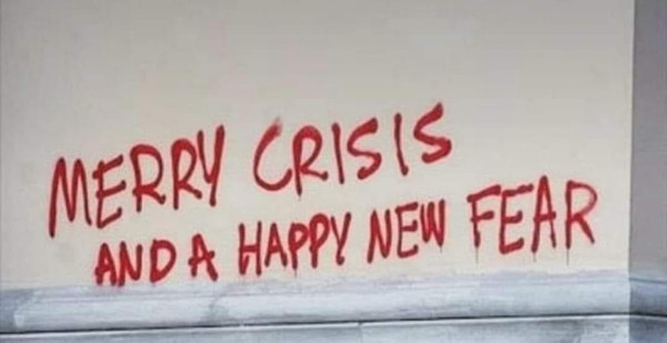 Spray paint on a wall that says MERRY CRISIS AND A HAPPY NEW FEAR