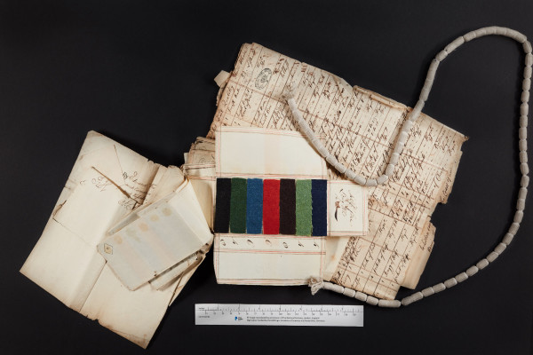 In the picture, we see several dozens of cloth samples in various colours (black, green, blue, red, brown, light green, blue) found among the court records of the High Court of Admiralty relating to the ship Jupiter. Textile samples, whether wool, silk, linen or cotton can often be found in the Prize Papers collection, as fabrics were often sent in letters, were part of a captured ship’s cargo or were owned by crewmembers. Some samples are in block colors while others are printed and we have examples from as far away as India and Canton.
The National Archives, ref. HCA 32/125/21. Images reproduced by permission of the National Archives, UK.