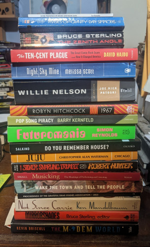 pile of books
Some Writing on Music & Musicians / Lee Ranakdo
Phases of gravity/ Dan Simmons
the zenith angle / Bruce sterling
ten cent plague / David hajdu
night sky mine / Melissa Scott 
willie nelson / joe nick patoski
1967 / Robyn hitchcock
pop song piracy / Barry kernels
futuromania / Simon Reynolds
do you remember house / salkind
juju / Christopher Alan Waterman
silver snarling trumpet / Robert Hunter
musicking / Christopher small
wake the town & tell the people / stoloroff
not since Carrie / Ken mandelbaum
proceedings of the grateful dead studies association 2023
mirrorshades / bruce sterling, editor
the modem world / Kevin driscoll